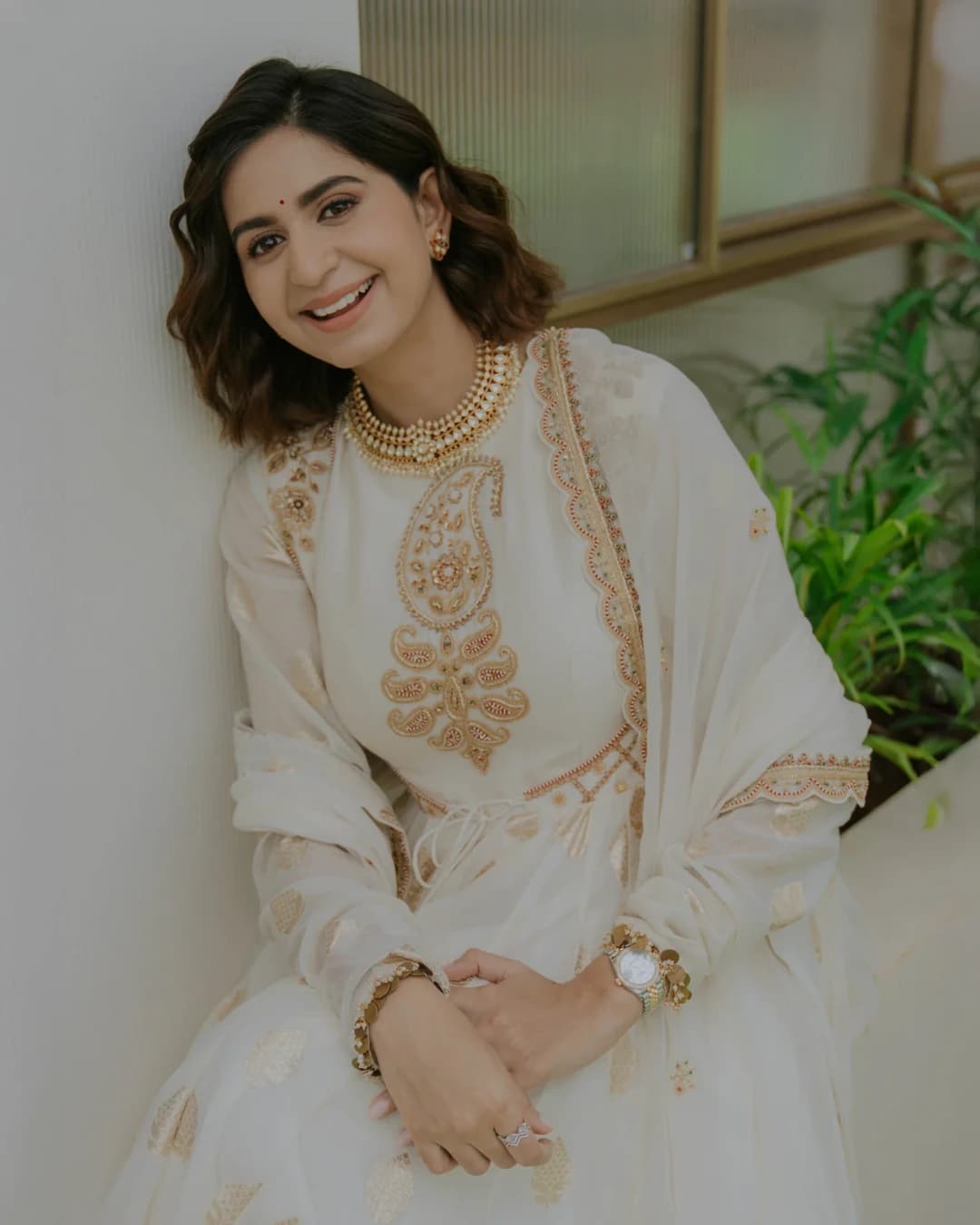 Kinjal Dave smiling in an ivory embroidered outfit